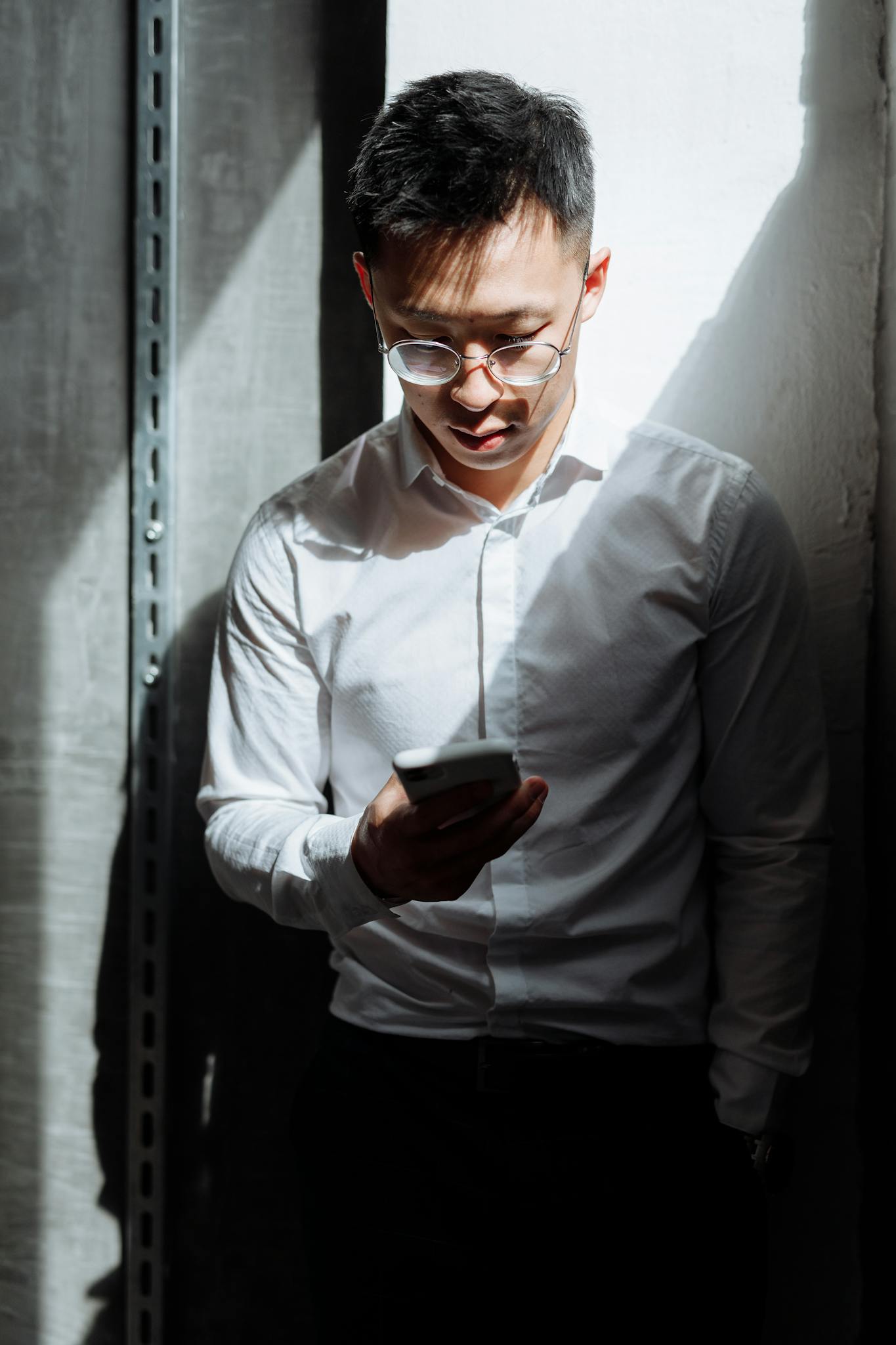 Man in Gray Dress Shirt Holding Black Smartphone